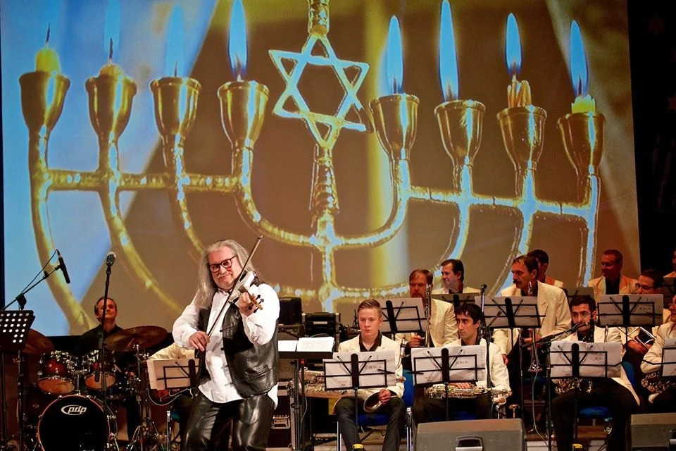 Igor Epstein spielt Geige vor weiteren Musikern auf einer Bühne